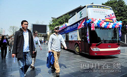 在寬窄巷子，幾位外國(guó)游客從世博大巴旁經(jīng)過(guò)