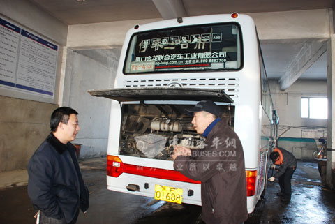 駕駛員李峰（右）正在與廠商代表交流車輛保養經驗